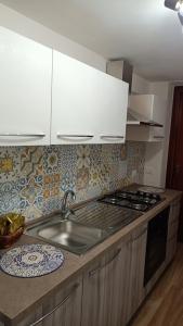 uma cozinha com um lavatório e um fogão forno superior em Scirocco e Maestrale em Petrosino