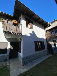 a white house with a porch and a balcony at Les Arnauds in Bardonecchia