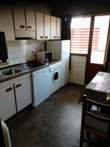 a kitchen with white cabinets and a sink and a dishwasher at Vivienda uso turistico El Vie in Villarcayo