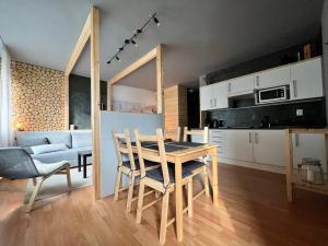 a kitchen and dining room with a table and chairs at Apartmán Pinus in Donovaly