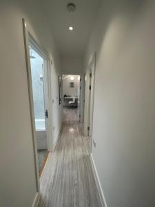 un couloir avec une porte s'ouvrant sur une chambre dans l'établissement Modern London Apartment, à Londres