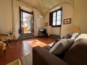 a living room with a couch and a tv at Tenuta Torre Rossa Farm & Apartments in Impruneta