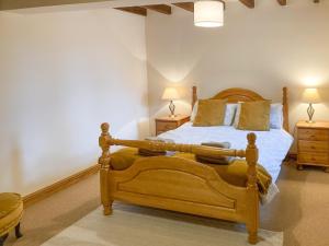 a bedroom with a wooden bed and two night stands at The Hop Bind in Bromyard