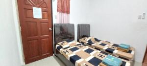 a bedroom with two beds and a brown door at Taras Homestay in Seribu
