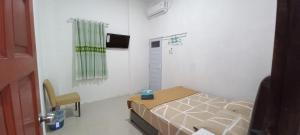 a small room with a bed and a window at Taras Homestay in Seribu