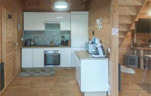 een keuken met witte kasten en een aanrecht bij Nice Home In Bourbourg With Wifi And 2 Bedrooms in Bourbourg