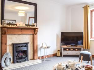 a living room with a fireplace and a mirror at Primrose Cottage in Ironbridge