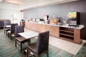 a restaurant with tables and chairs and a counter at Residence Inn Dallas Park Central in Dallas