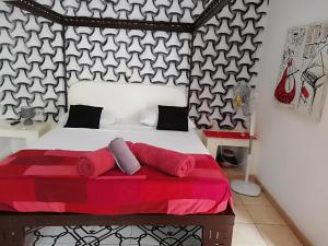 a bedroom with a bed with a red blanket at Riad côté jardin in Saly Portudal