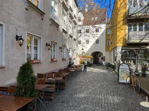 eine Straße mit Holztischen und Bänken in einer Stadt in der Unterkunft Altstadtjuwel Liboria in Augsburg