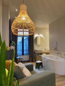 a large bathroom with a tub and a large chandelier at B&B Toast Hoogstraten in Hoogstraten
