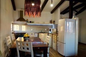 uma cozinha com uma mesa de madeira e um frigorífico em Apartment Barone Šibenik - city view & free parking em Sibenik