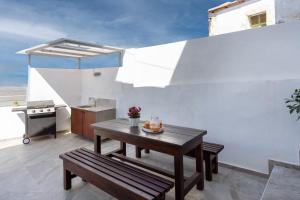 a small kitchen with a table and benches in a room at Avli Village Home with Outdoor Jacuzzi in Vafés