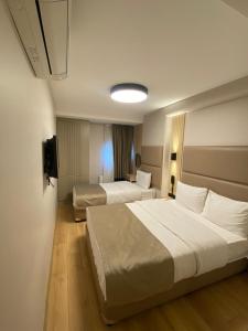 a hotel room with two beds and a television at Otel Yenikapı in Istanbul