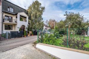 une rue vide avec une clôture et un bâtiment dans l'établissement Wawabed Aparthotel, à Varsovie