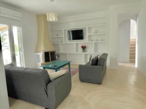 uma sala de estar com dois sofás e uma lareira em The Velanidies - Οι Βελανιδιές em Agia Marina