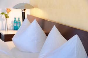a group of white pillows sitting on a bed at Hotel Roth am Strande in Westerland
