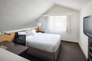 a hotel room with a bed and a desk and a television at Residence Inn Pasadena Arcadia in Arcadia