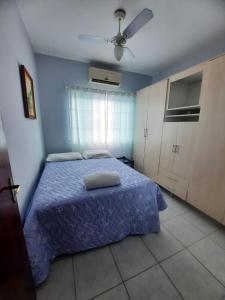 1 dormitorio con 1 cama y ventilador de techo en casa no paraíso do Capri, en São Francisco do Sul