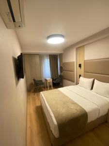 una habitación de hotel con una cama grande y una mesa en Otel Yenikapı, en Estambul