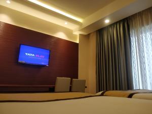 a hotel room with a tv on a wall at Golden Retreat in Baharampur