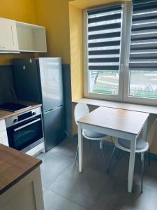 uma cozinha com uma mesa e cadeiras e um frigorífico em Friendly Apartment em Cracóvia