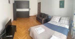 um quarto com uma cama e uma cadeira em Friendly Apartment em Cracóvia