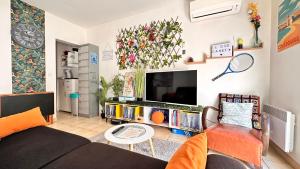 een woonkamer met een bank en een tv bij LE COSY Canet - Studio 2 personnes à 30m de la plage, wifi fibre clim netflix in Canet-en-Roussillon