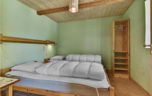 1 cama con almohadas blancas en una habitación en Fuglsang, en Tranekær