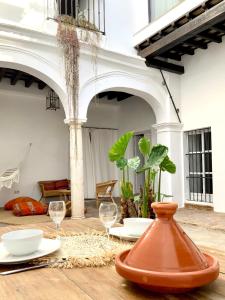 un patio con 2 vasos y un jarrón sobre una mesa en Casa Bablou, en Sanlúcar de Barrameda