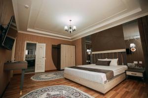 una camera con un grande letto e un lampadario a braccio di FAYZ a Urganch
