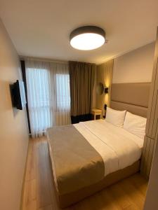 um quarto de hotel com uma cama e uma televisão em Otel Yenikapı em Istambul
