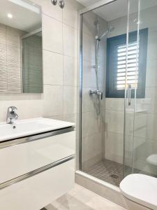 uma casa de banho com um chuveiro, um lavatório e um WC. em Apartamentos Stella Maris em Roses