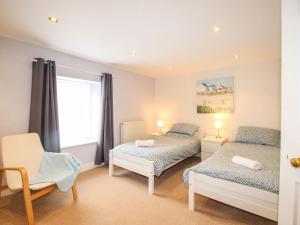 a bedroom with two beds and a chair and a window at Pebble Reef in Portland