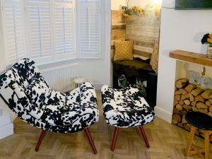 two chairs in a living room with a fireplace at Whitstable'S Pearl in Whitstable