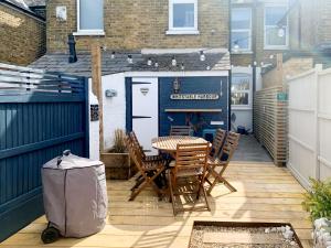 a patio with a table and chairs and a garage at Whitstable'S Pearl in Whitstable