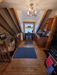 Cette chambre comprend une cuisine avec une table et une fenêtre. dans l'établissement Baidland Escapes 2 bedroom cottage With hot tub, à Dalry