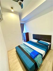 Schlafzimmer mit einem Bett mit blauer und weißer Bettwäsche in der Unterkunft 20 BukitJalil Pavilion - 2bedroom - HighFloor - 吉隆坡 in Kuala Lumpur
