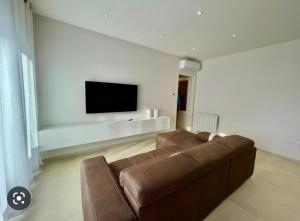 a living room with a couch and a flat screen tv at Nature Apartment in Olbia