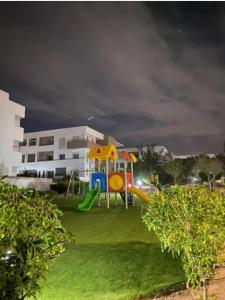 - une aire de jeux avec toboggan dans un parc la nuit dans l'établissement Résidence Tafoult complexe Lunja village Agadir Imiouadar, à Agadir nʼ Aït Sa