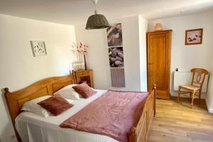 a bedroom with a large bed and a chair at Ombre Bleue Du Figuier, Ailhon in Ailhon