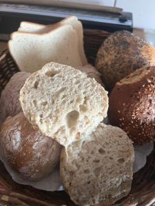 a basket filled with bread and other bread items at Lilla Hotellet Bed & Breakfast i Alingsås in Alingsås
