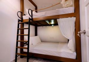 a bunk bed in a room with a ladder at Leisure Lodge in Kuala Terengganu