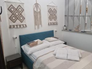 a bedroom with a blue and white bed with pillows at Apartament BURSZTYNEK in Pobierowo