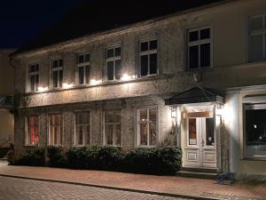 un viejo edificio de piedra con luces encendidas por la noche en Spurensucher Quartier, en Usedom Town