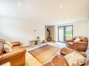 a living room with leather furniture and a fireplace at The Granary in Inglewhite