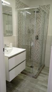W łazience znajduje się szklana kabina prysznicowa i umywalka. w obiekcie Gemini camere e suites w mieście Grosseto