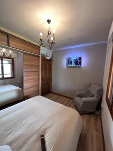 um quarto com uma cama e uma cadeira e uma televisão em Casa rural completa en plena naturaleza em Eguíllor