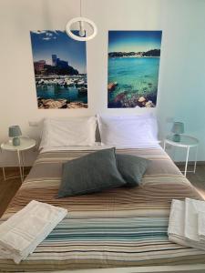 een slaapkamer met een groot bed met twee foto's aan de muur bij Colombo 32 Affittacamere in La Spezia