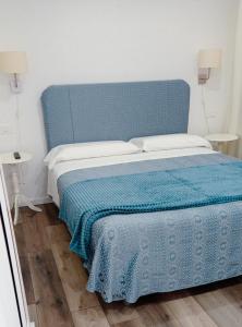 a bed with a blue headboard in a room at Gemini camere e suites in Grosseto